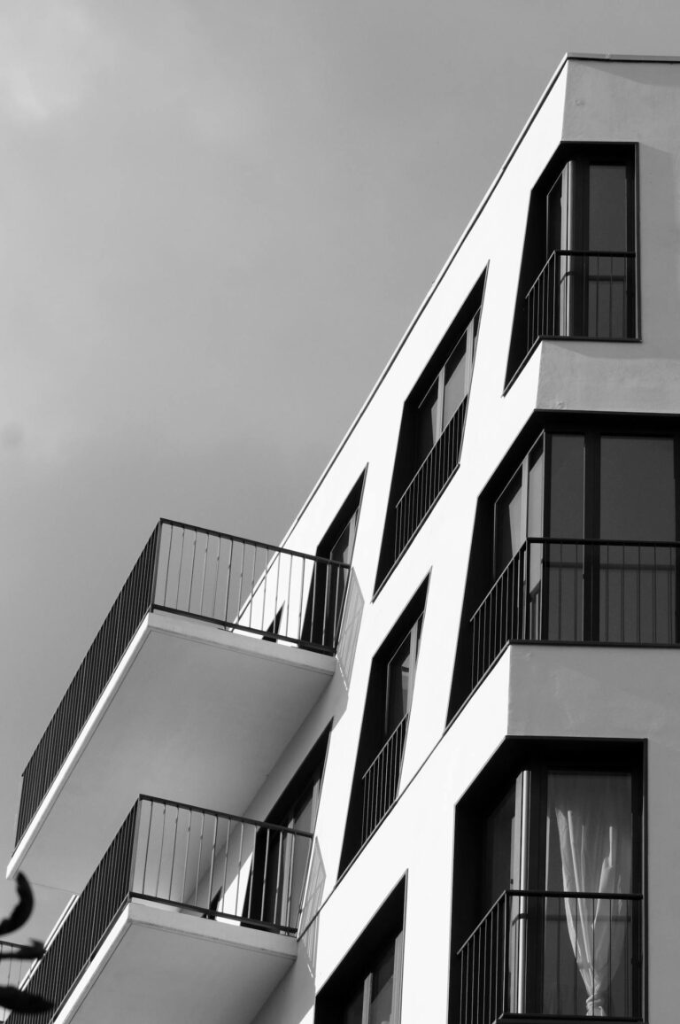 Black and white photo of a modern geometric building facade with balconies.